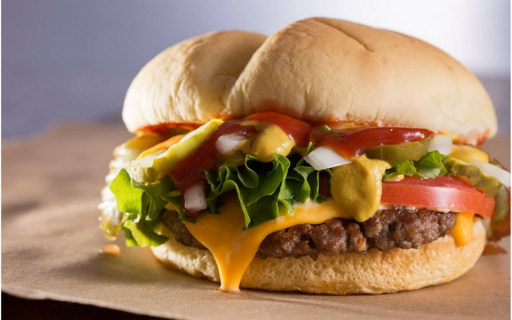 Cheeseburger with lettuce and tomato on a bun made by Wayback Burgers.