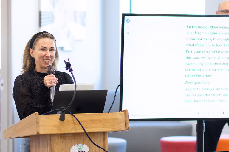 Aspire Living & Learning CEO Erica Hare address crowd at ribbon cutting event in Massachusetts.